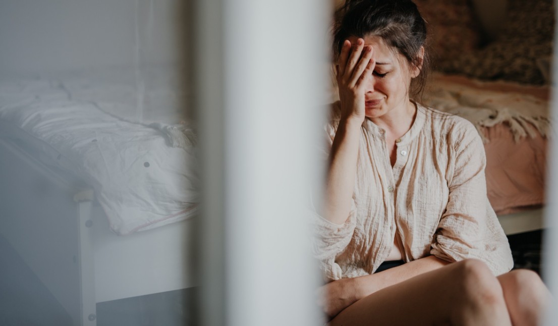 Huilende vrouw hand voor gezicht naast Libelle-artikel over jong verlies van Iris Koorn’s ouders – emotie en verlies zichtbaar.